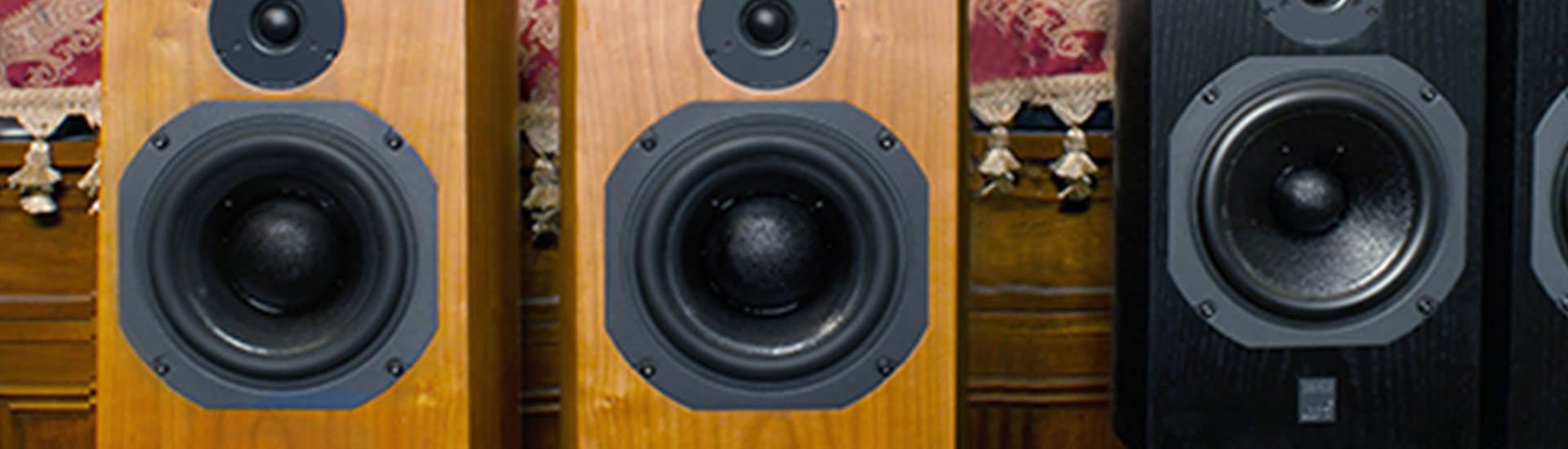 Close-up of loudspeaker drivers in walnut and black cabinets